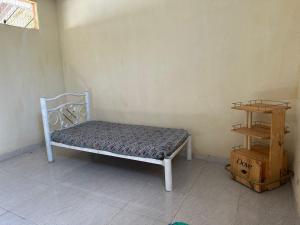 Una cama en un rincón de una habitación con un estante. en Espaço Shekinah, en Engenho Araci