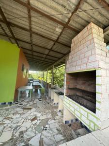 Un patio al aire libre con chimenea de ladrillo y mesas. en Espaço Shekinah, en Engenho Araci