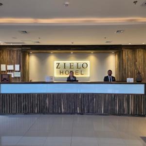 two men standing at the reception counter of a hotel at Zielo Hotel in Asuncion
