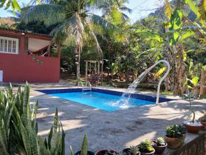 a swimming pool with a waterfall in a yard at Chácara da Madrinha in Guarapari