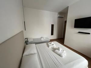 a bedroom with two beds and a flat screen tv at La Terrazza in centro in Marsala
