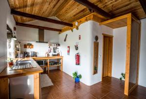 a kitchen with wooden ceilings and a wooden floor at Casa Kasule - RRAL4671 in Lajes das Flores