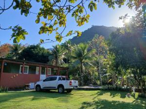 a white truck parked in front of a house at Chácara da Madrinha in Guarapari