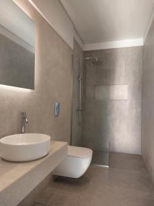a bathroom with a toilet and a sink and a shower at Hesperian Luxury Villas in Chania Town