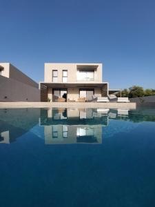 a house with a pool of water in front of it at Hesperian Luxury Villas in Chania Town