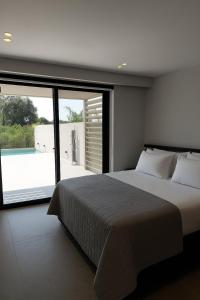 a bedroom with a large bed and a large window at Hesperian Luxury Villas in Chania Town +21 photos