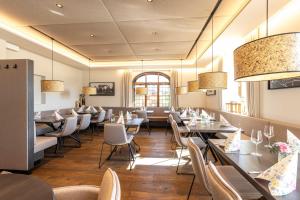 a dining room with tables and chairs and lights at Hotel am Wald in Bad Tölz