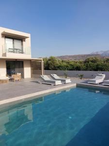 a house with a swimming pool in front of a house at Hesperian Luxury Villas in Chania Town