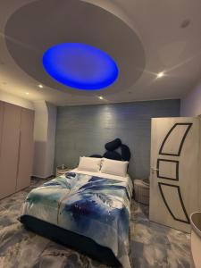 a bedroom with a large blue light above a bed at Naomi Luxury Home 3 in Catania +6 photos