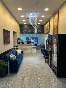 a lobby with a blue couch in a waiting room at Hotel Aero Sleep Campinas in Campinas