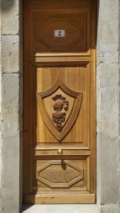 a wooden door with a crest on it at T2 Design Centre Cité 10 min in Carcassonne