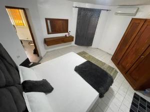 a bedroom with a white bed and a bathroom at ParadisPlage, 1 minute de la mer in Saly Portudal +15 photos