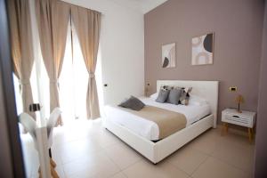 a bedroom with a white bed and a large window at B&B Feni in Pompei