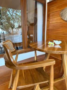 a wooden table and a chair and a table at Jaya Beach Bungalows in Gili Islands