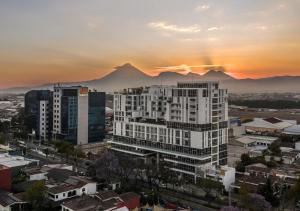 a view of a city with mountains in the background at Airport and Volcano Views from 11th Floor Apartment in Guatemala
