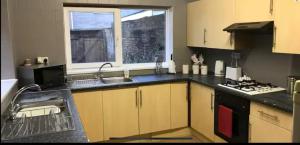a kitchen with a sink and a stove and a window at 284 - Room 5 - Beachfront - Fantastic sea views in Swansea