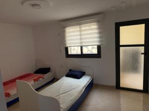 een kleine kamer met twee bedden en een raam bij Moul Partma Saidia Joss in Saidia 