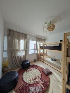 Un dormitorio con literas y una alfombra grande. en sea view apartment with rooftop in Aourir, en Agadir