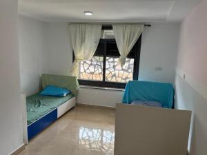 een kleine kamer met twee bedden en een raam bij Moul Partma Saidia Joss in Saidia 