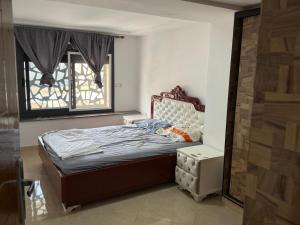 een kleine slaapkamer met een bed en een raam bij Moul Partma Saidia Joss in Saidia 