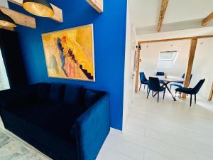 a blue living room with a couch and a table at Apartamentai senamiestyje Klaipėdos inkarai in Klaipėda
