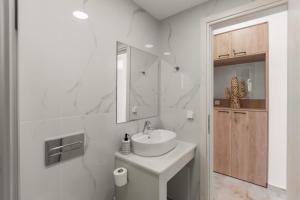 a white bathroom with a sink and a mirror at Star Studios Paros in Kampos Paros +95 photos
