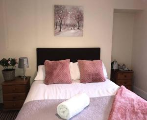 a bedroom with a bed with pink and white pillows at 284 - Room 7 - beachfront in Swansea
