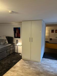 a living room with a bed and a white cabinet at Ruhige 1 Zimmerwohnung Souterrain in Bortfeld