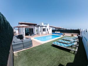 a backyard with a swimming pool and a villa at Villa Romans in Caleta De Fuste