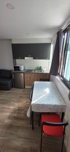 Una cocina con una mesa con una silla roja al lado. en El rincon, en Cambados