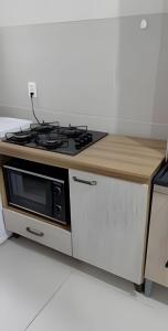 a kitchen with a stove and a microwave at Apartamento POP Panazzolo in Caxias do Sul +15 photos