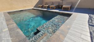 a swimming pool with chairs in a house at Villa individuelle 3 chambres - 6 pers in Calvi