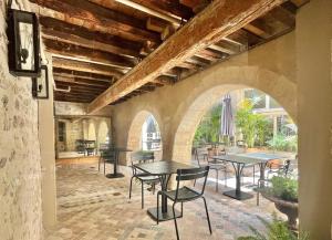 a patio with tables and chairs in a building at la Maison Molière in Arles