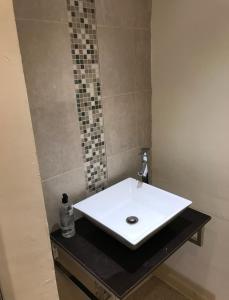 ein Badezimmer mit einem weißen Waschbecken auf einer schwarzen Theke in der Unterkunft 284 - Room 8 - Beachfront - Fantastic Sea views in Swansea