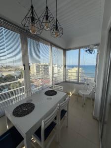 a kitchen with a table and chairs in a room with windows at Atalanta rooms in Larnaca