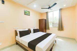 a bedroom with a large bed with a window at Hotel O Happy Times Vishveshwar Park in Gomti Nagar +20 photos