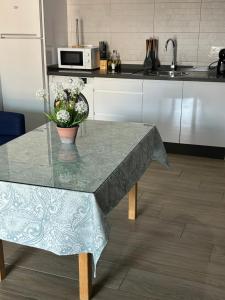 a kitchen with a table with a vase of flowers on it at Apartamentos Turisticos Ilusiones 2 in Cazalla de la Sierra