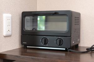 a black toaster oven sitting on top of a table at Forest and Stars Akakura Luxe in Myoko
