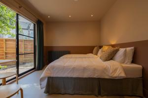 a bedroom with a large bed and a large window at Lin Song House South London Garden Room Getaway in London