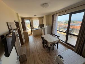 a kitchen and dining room with a table and a window at Luxury Apartments Ekaterina in Chernomorets