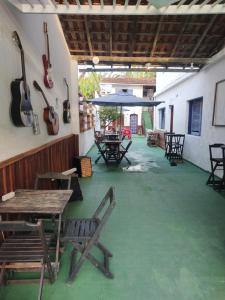 a patio with tables and chairs and guitars on the wall at Pousada Villa Da Música Beira Mar Lótus Pontal Centro in Paraty