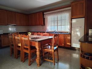 a kitchen with a wooden table and wooden chairs at Forxan in Sanxenxo