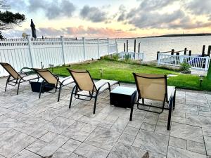 a group of chairs sitting on a patio by the water at Me-Skye waterfront retreat in Baldwin