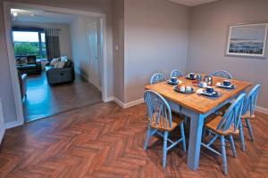 a dining room with a wooden table and chairs at Willan Cottage in Portrush