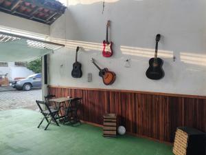 a room with acoustic guitars hanging on the wall at Pousada Villa Da Música Beira Mar Lótus Pontal Centro in Paraty +29 photos