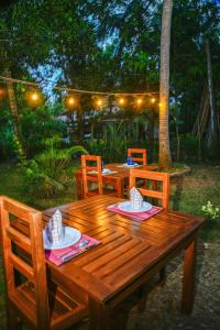a wooden table with chairs and plates on it at Wild Heaven Udawalawe in Udawalawe