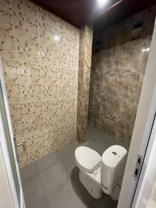 a bathroom with a toilet and a shower at Pradnya Homestay Ungasan - Room near Uluwatu in Uluwatu