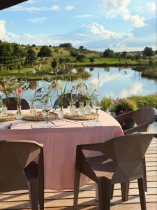a table with vases of flowers and a lake at Aurora Resort in Stasiūnai