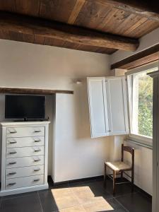 a room with a dresser with a tv and a chair at Affitti brevi FESAGI in Laurino