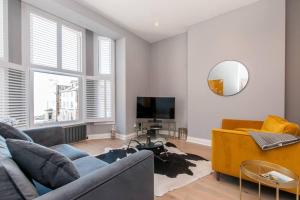 a living room with a couch and a mirror at Serenity By The Sea - Broadstairs in Kent